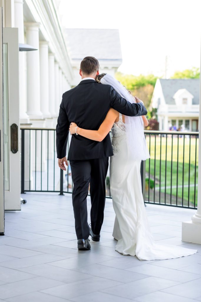 bride and groom leaving ceremony wrapping arms around one another at elegant spring washington golf and country club wedding