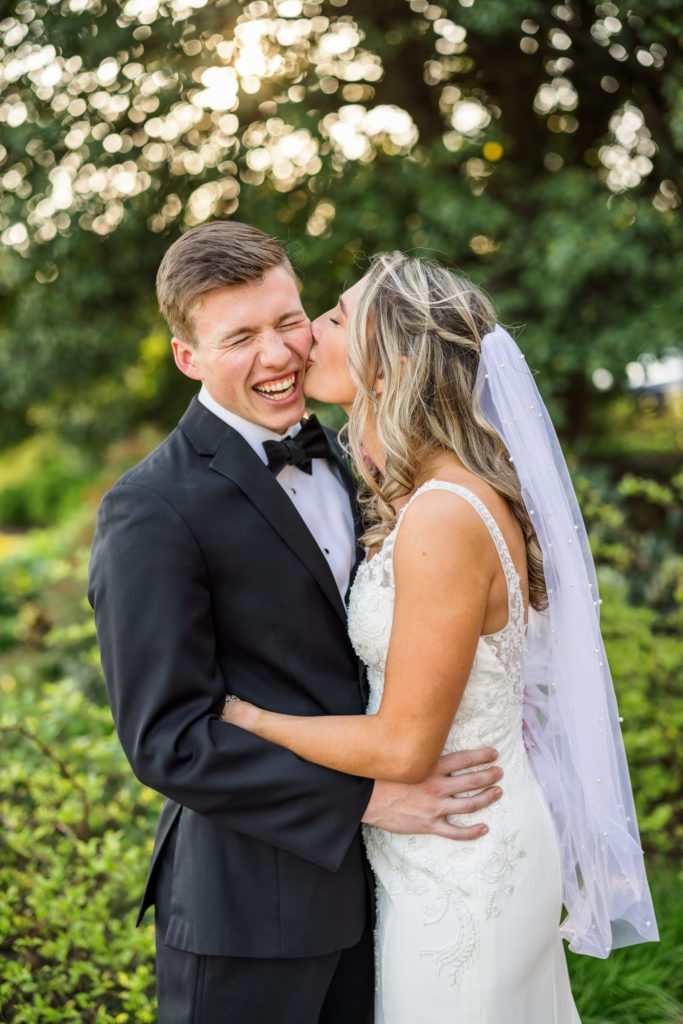 bride kissing groom's cheek after elegant spring washington Golf and Country Club wedding