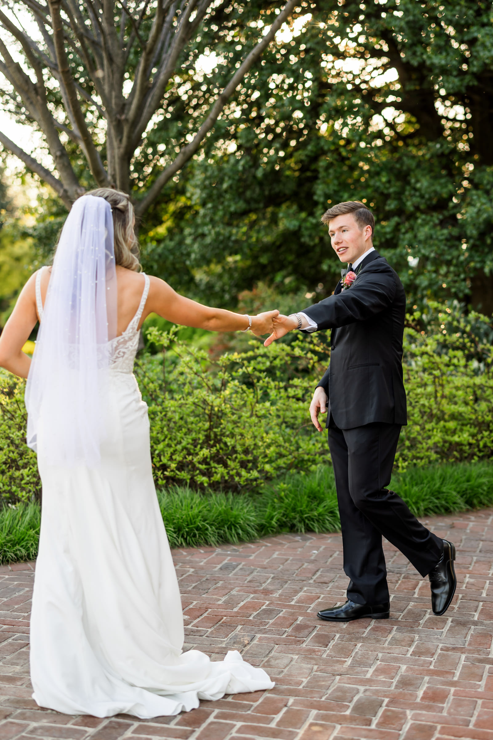 groom holding bride's hand dancing together 