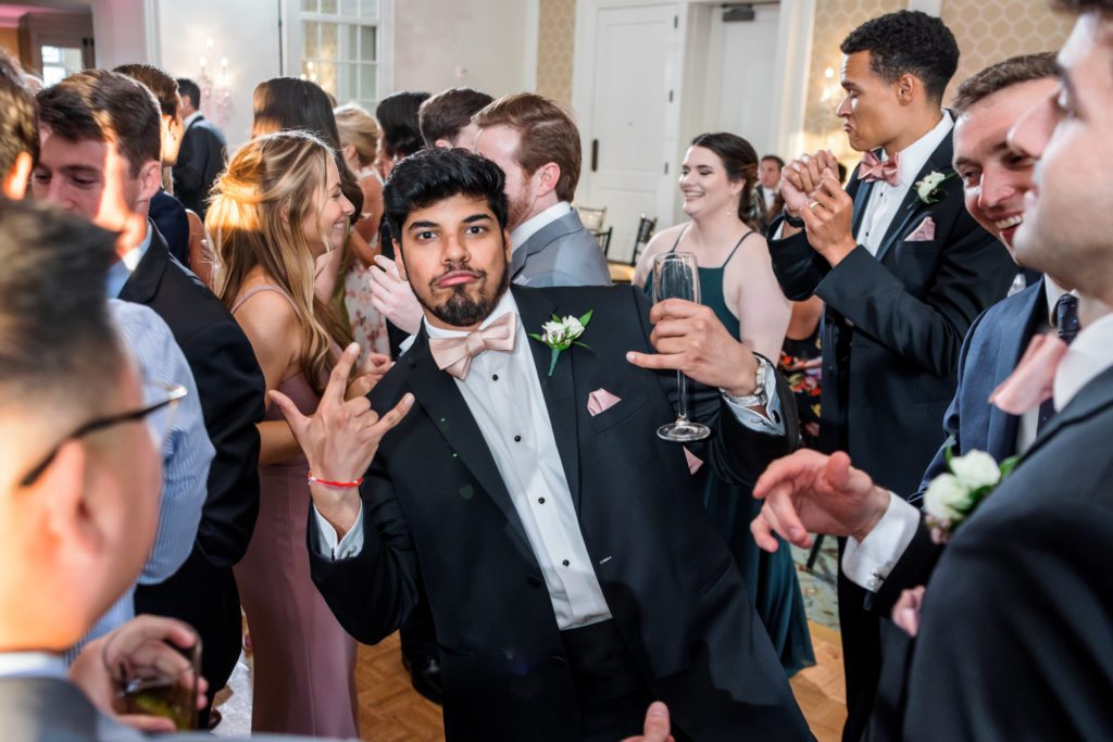 groomsmen making funny hand signs during entrance at reception