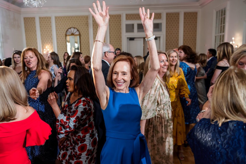 wedding guest with hands up celebrating 