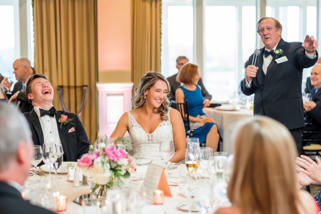 bride and groom sitting together laughing during wedding reception