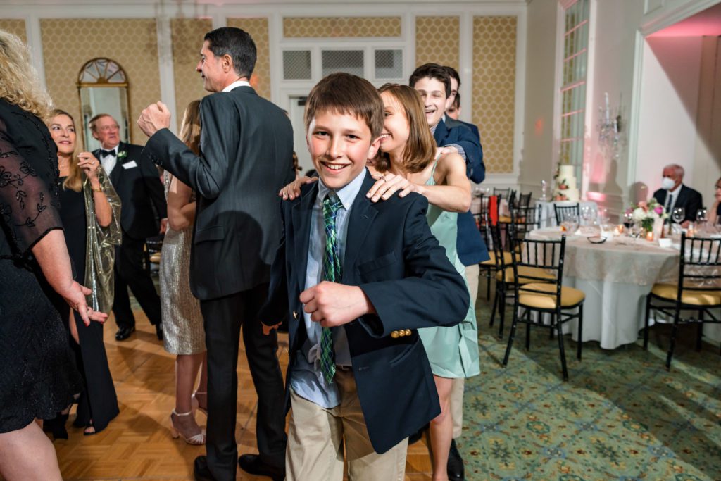 young kid dancing and leading line of guests