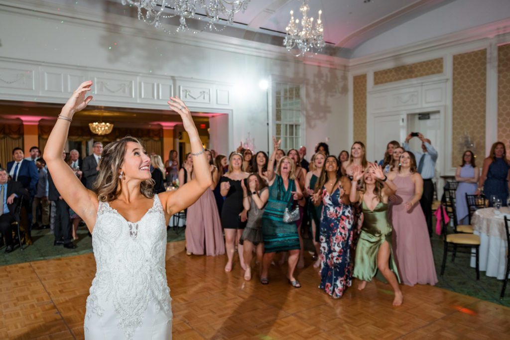 bride tossing wedding bouquet at spring black tie Washington Golf and Country Club reception