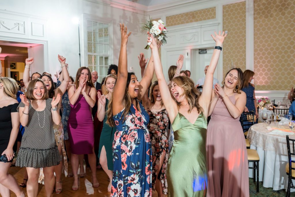 wedding guests going after bouquet at spring black tie Washington Golf and Country Club wedding