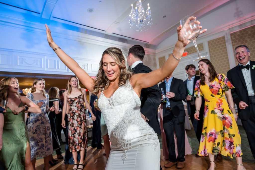 bride dancing with hands in air during evening reception