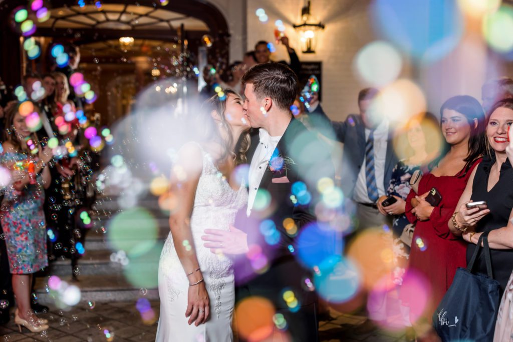wedding couple kissing during bubble exit at elegant spring washington golf and country club wedding reception