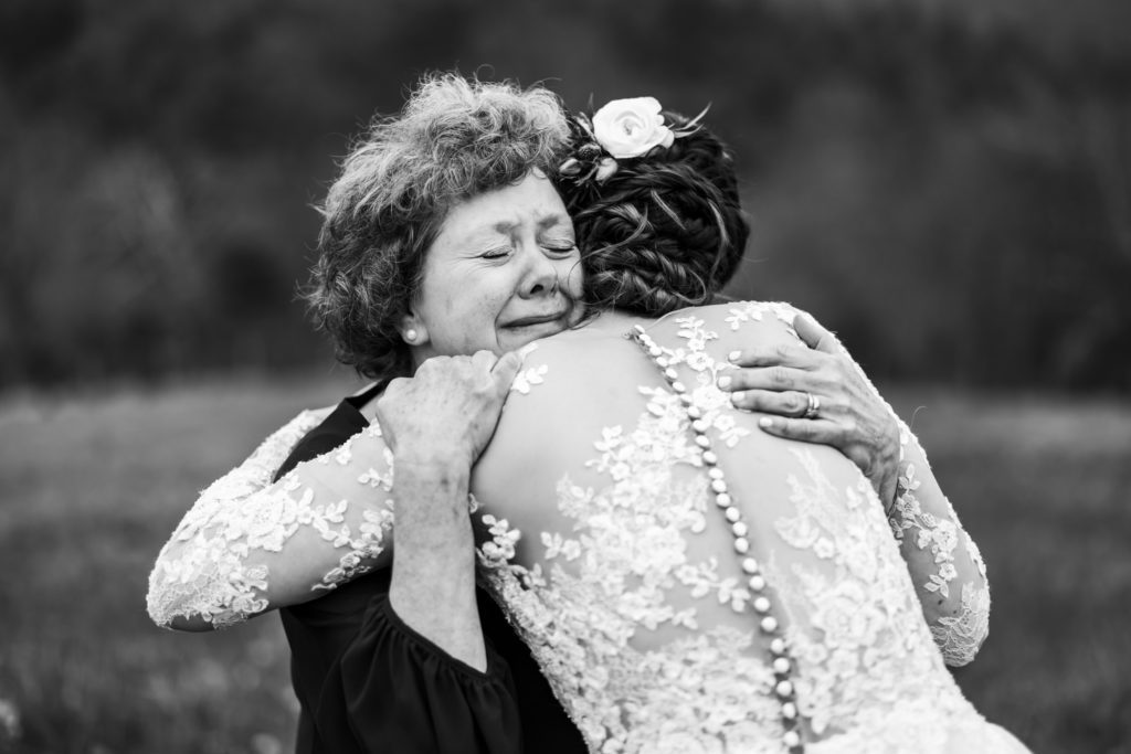 bride hugging mother before wedding ceremony at 12 Ridges Vineyard