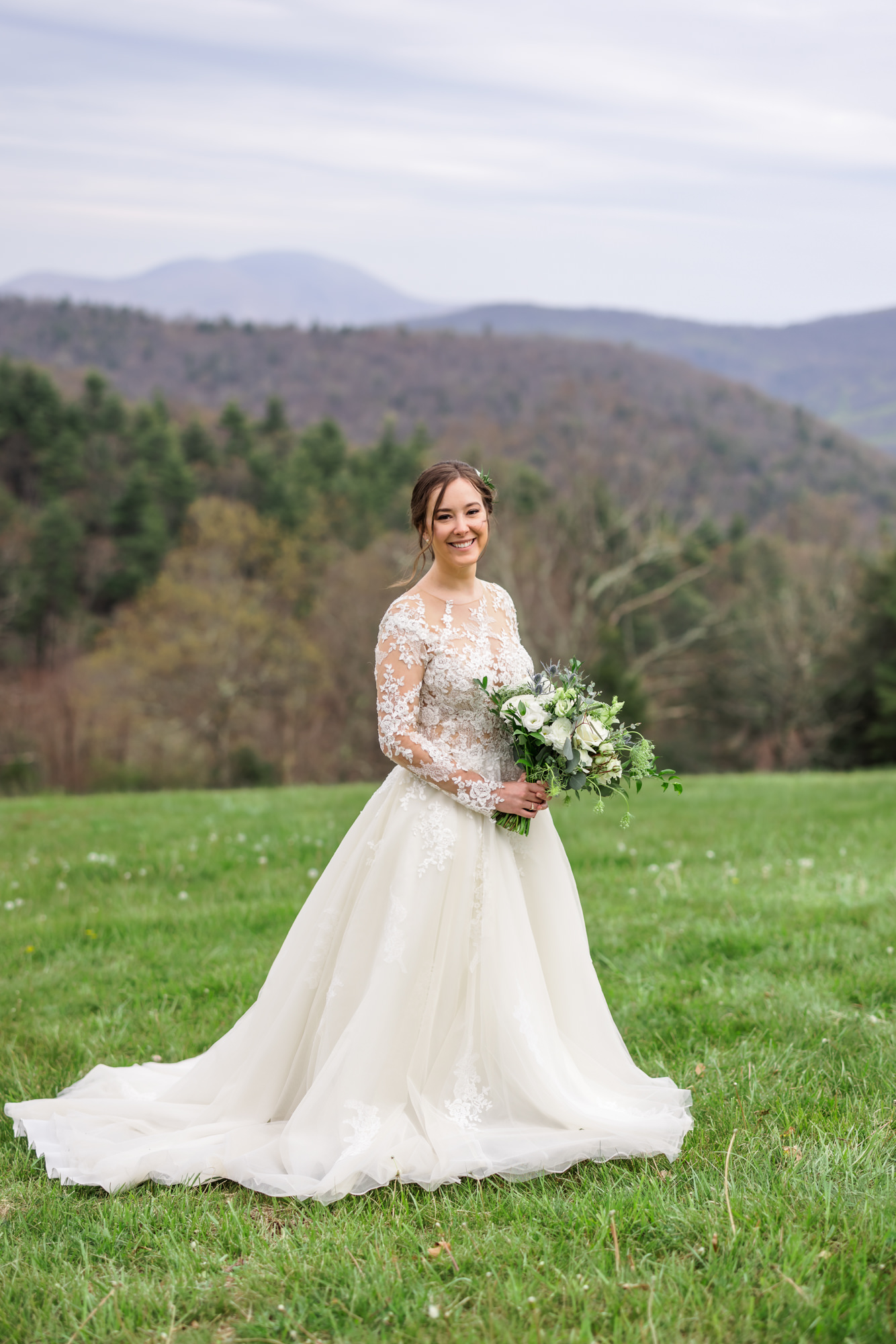 bride holding bouquet wearing bridal gown with lace long sleeves