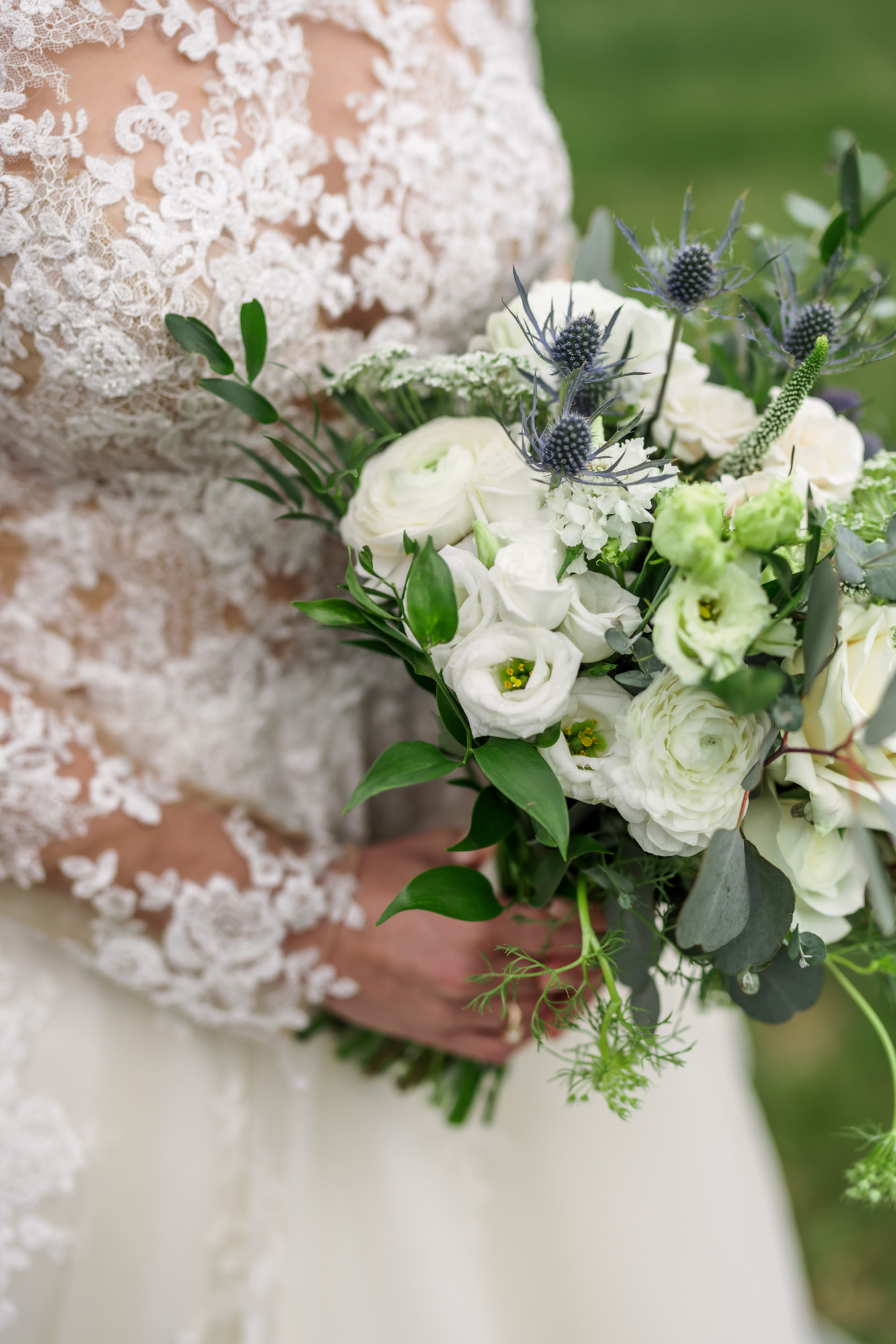 close up picture of bridal bouquet with greenery and white florals
