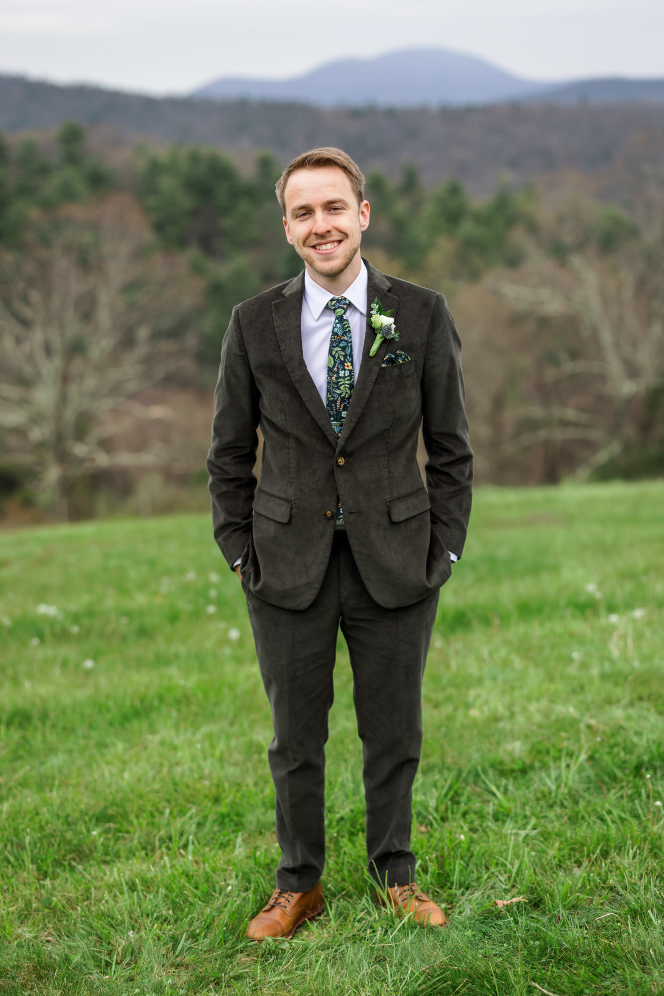 groom wearing olive suit with hands in pockets