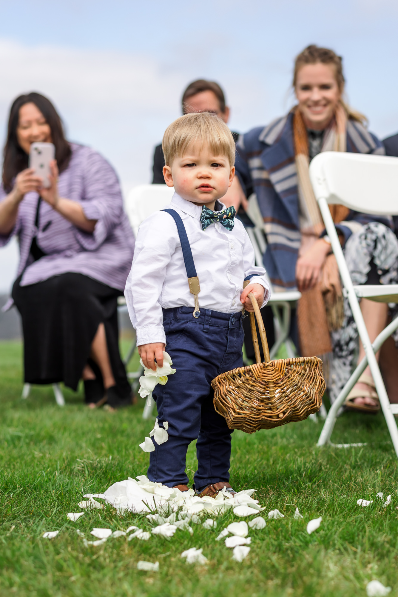 child holding flower petals and basket walking down the aisle