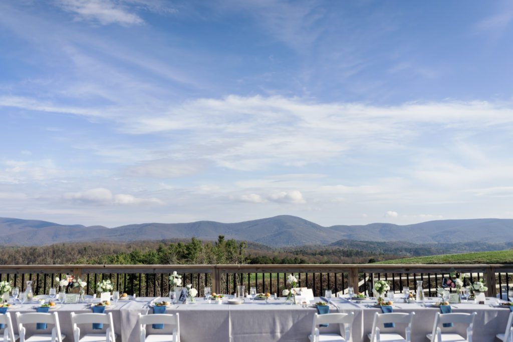 grand landscape view of the outdoor reception with tables and chairs overlooking the mountain view