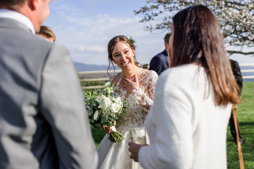 bride laughing and talking to guests during outdoor wedding reception