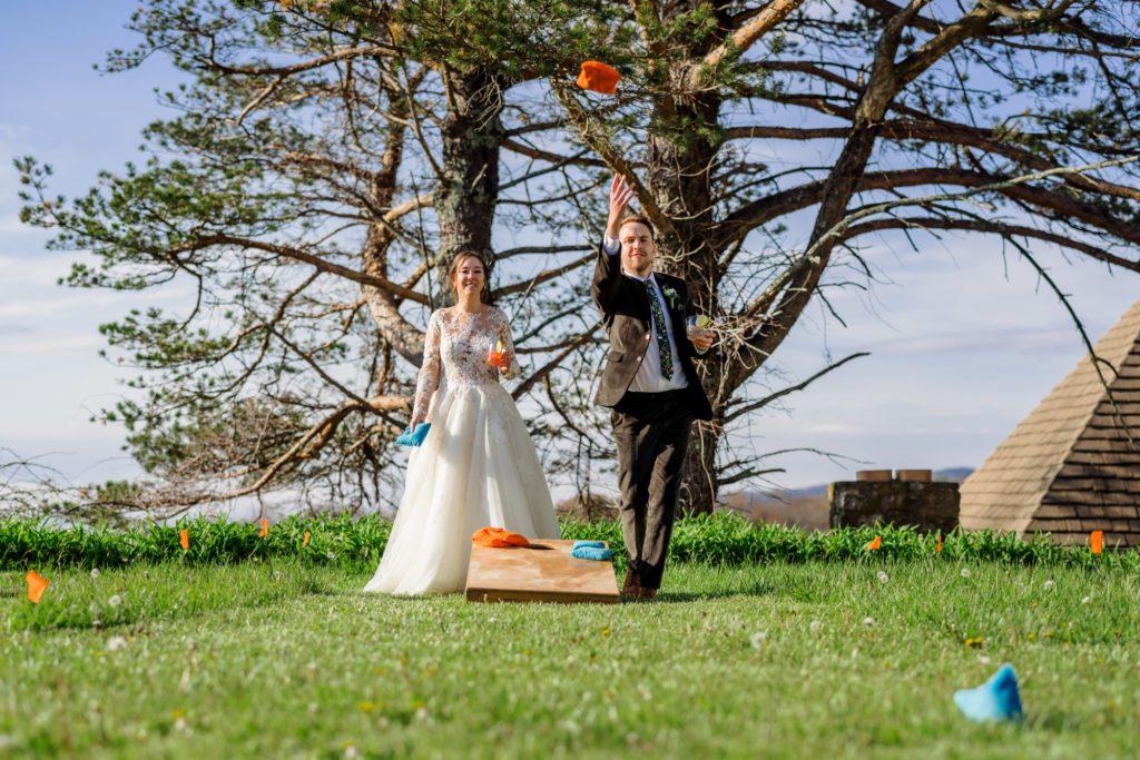 bride and groom playing games outdoors before wedding reception