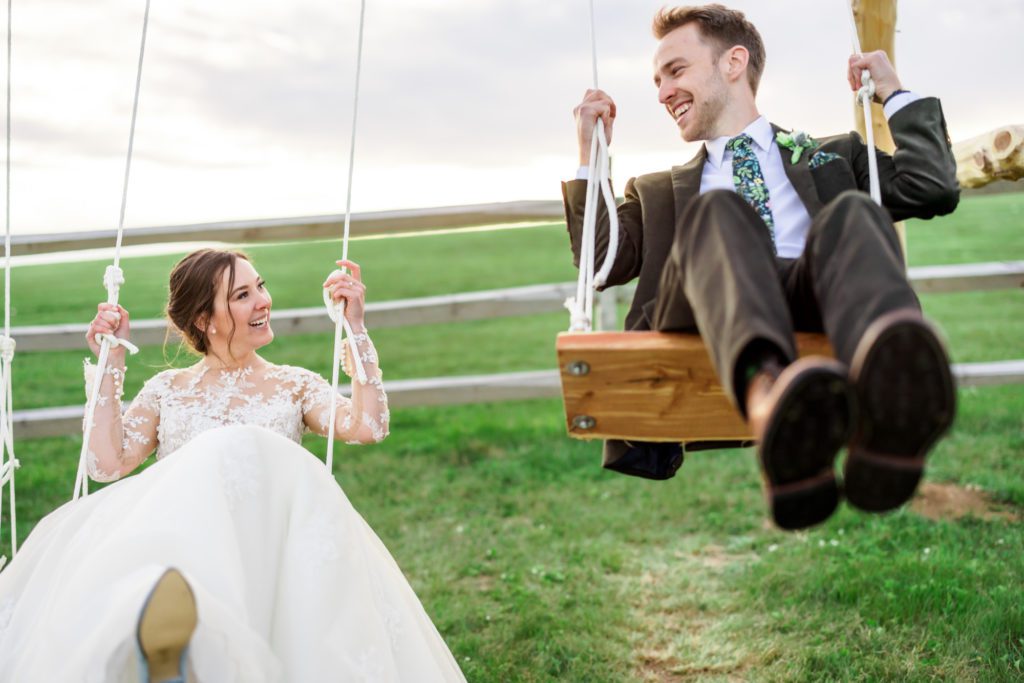 bride and groom swinging outside together 
