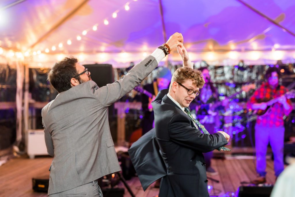 groomsmen dancing together on dance floor