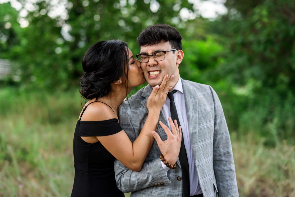woman kissing man's cheek during outdoor elegant belle isle engagement session