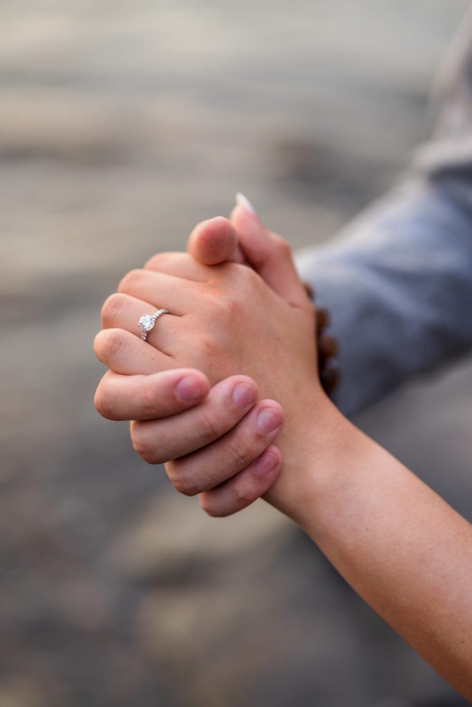 close up of couple's hands featuring engagement ring