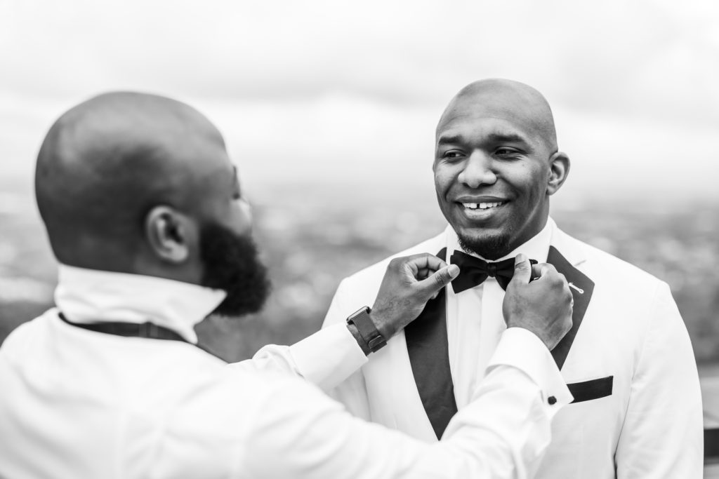 groomsmen adjusting bowtie on groom before spring black tie montaltso wedding