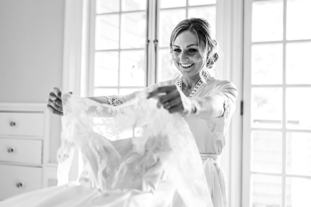 bride holding up wedding dress before getting ready before spring black tie montalto wedding ceremony
