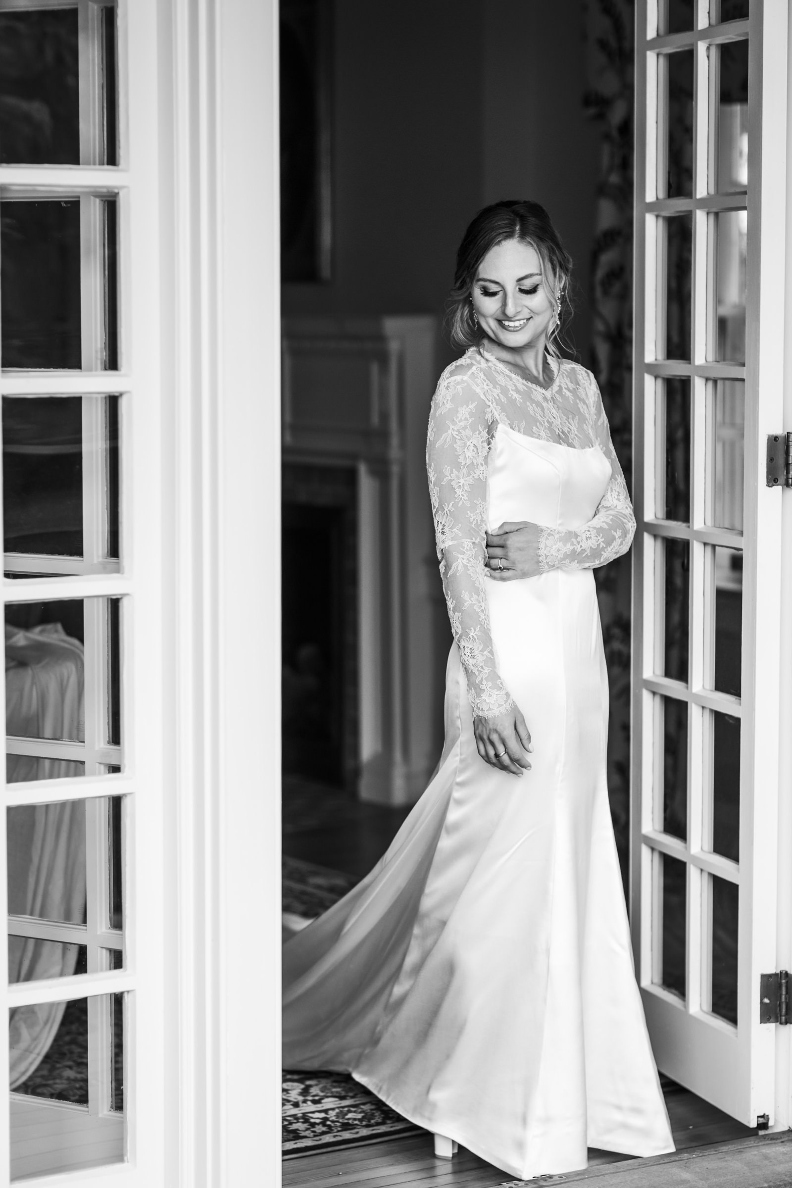 bride standing holding her dress smiling during portraits