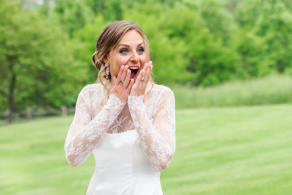 bride looking shocked while seeing bridesmaids for the first time in their bridesmaids' gowns