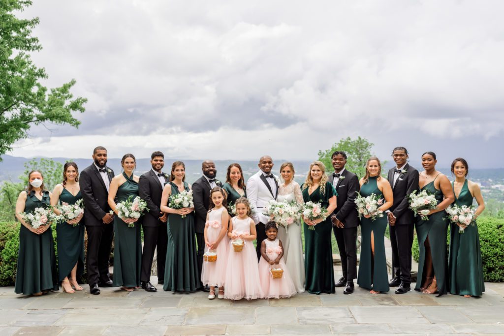 bride and groom standing with bridal party 