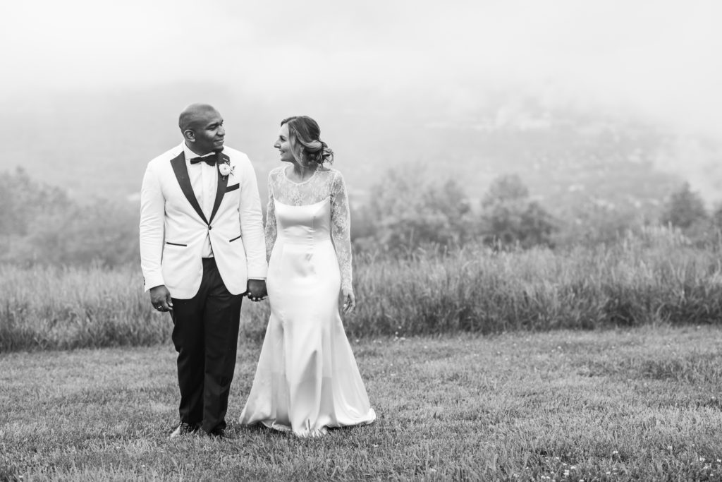 couple walking in field after ceremony