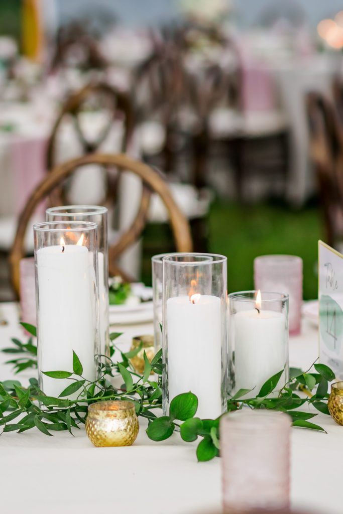 table centerpieces with tall candles and greenery