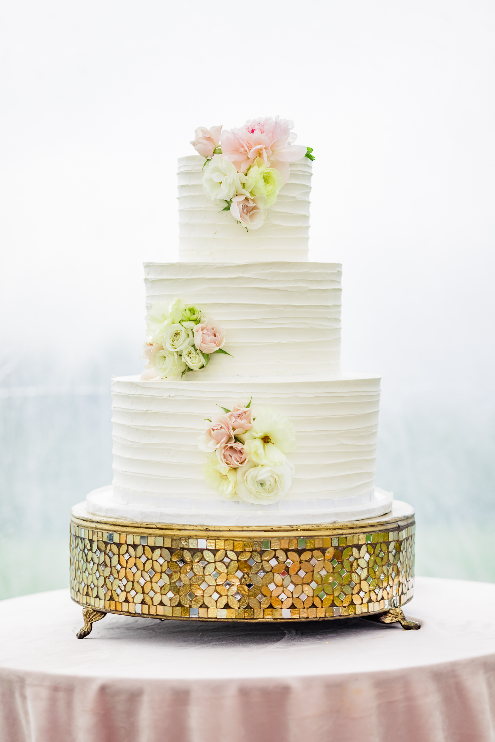three tiered wedding cake with pink and white flowers 
