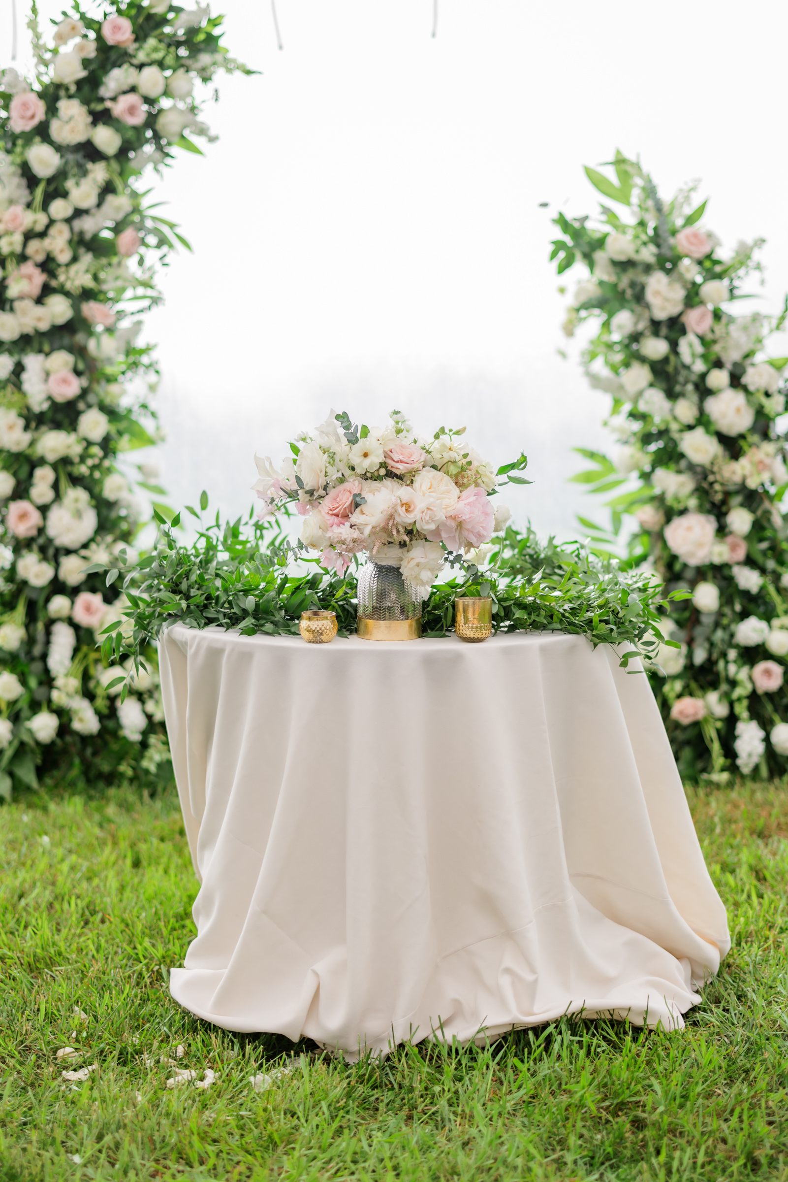 pink table cloth with greenery and flowers on top