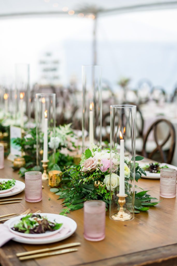table centerpieces with greenery and tall candles 