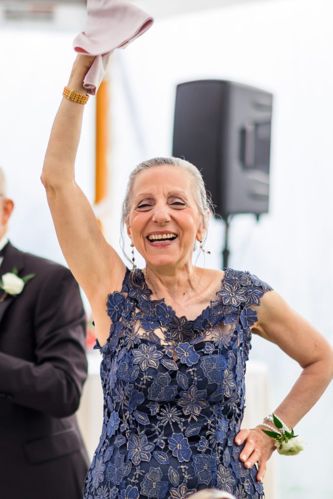 woman raising hand in the air while dancing after spring black tie montalto wedding ceremony