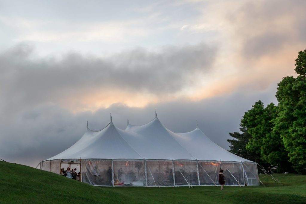 white tent with tables for evening reception