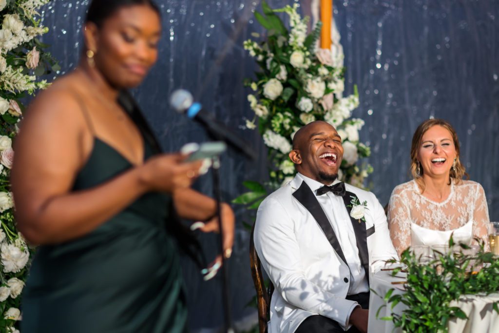 groom laughing out loud during toasts at evening reception
