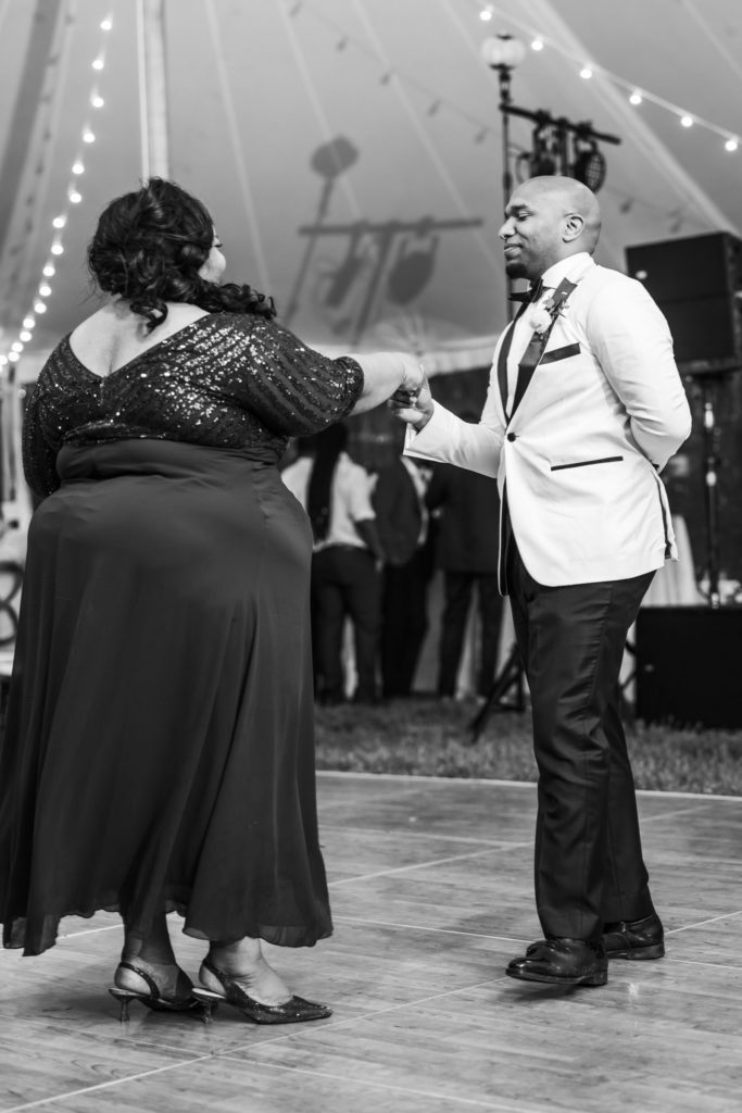 groom holding mother's hand while dancing