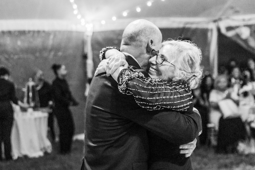 wedding guests hugging and smiling while dancing