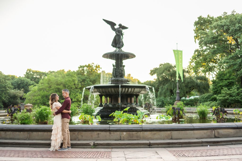 couple embracing in front of fountain at Bethesda Terrace engagement session