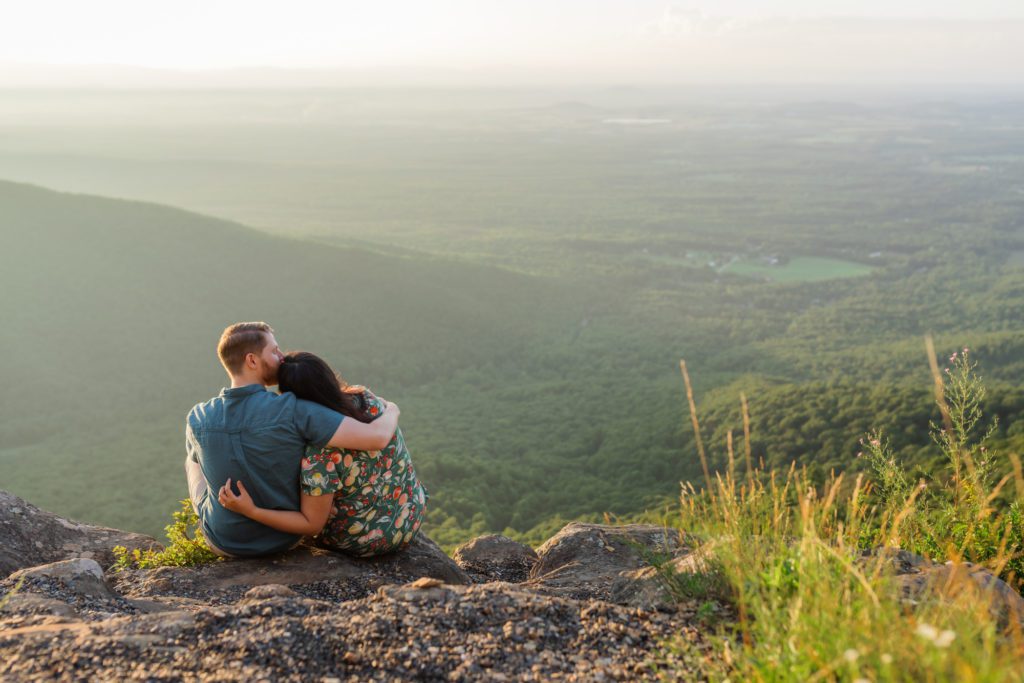 man and woman embracing while sitting on ledge at Ravens Roost