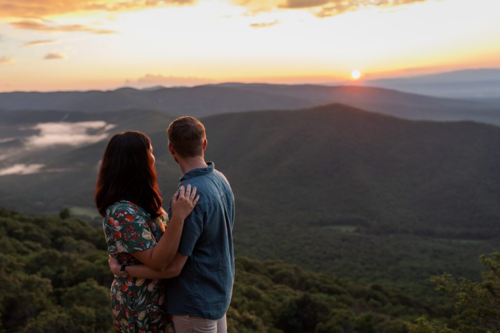 couple watching sunset at Summer Shenandoah National Park engagement session
