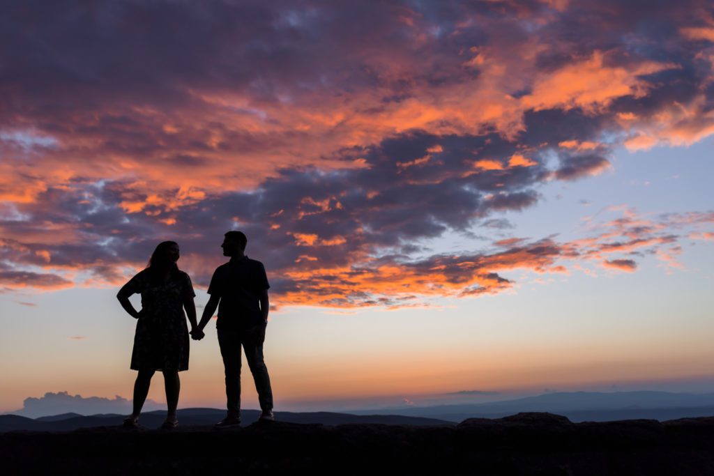 couple holding hands at sunset atop Ravens Roost