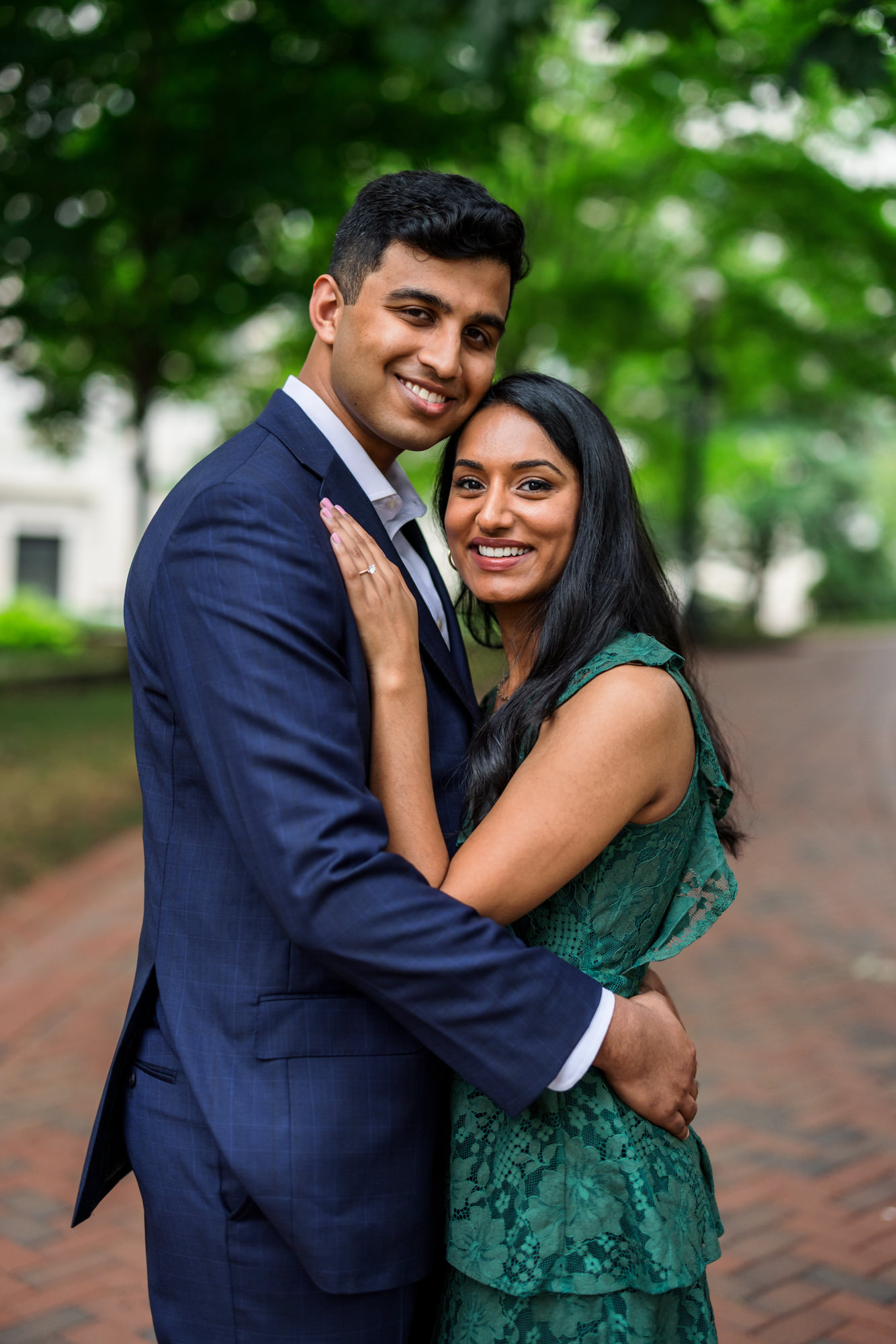 man and woman embracing, woman wearing emerald green dress and man wearing navy blue suit
