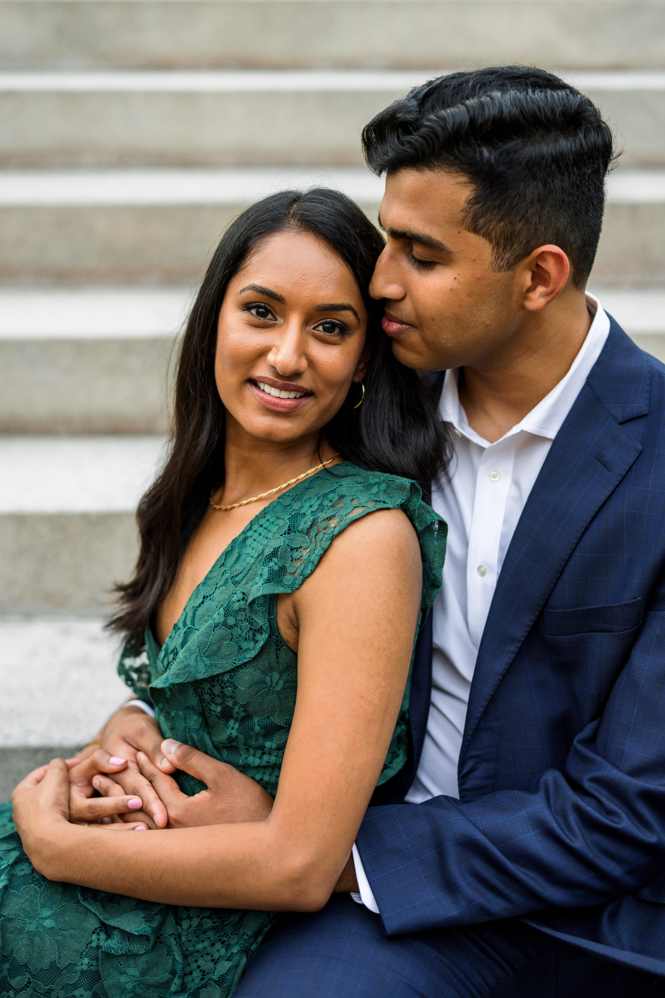 man holding woman sitting on steps during elegant richmond engagement session