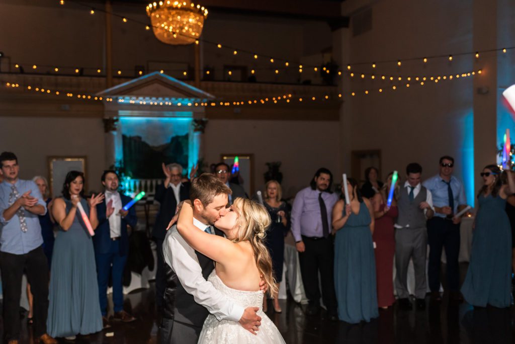 bride and groom kissing and dancing at indoor reception