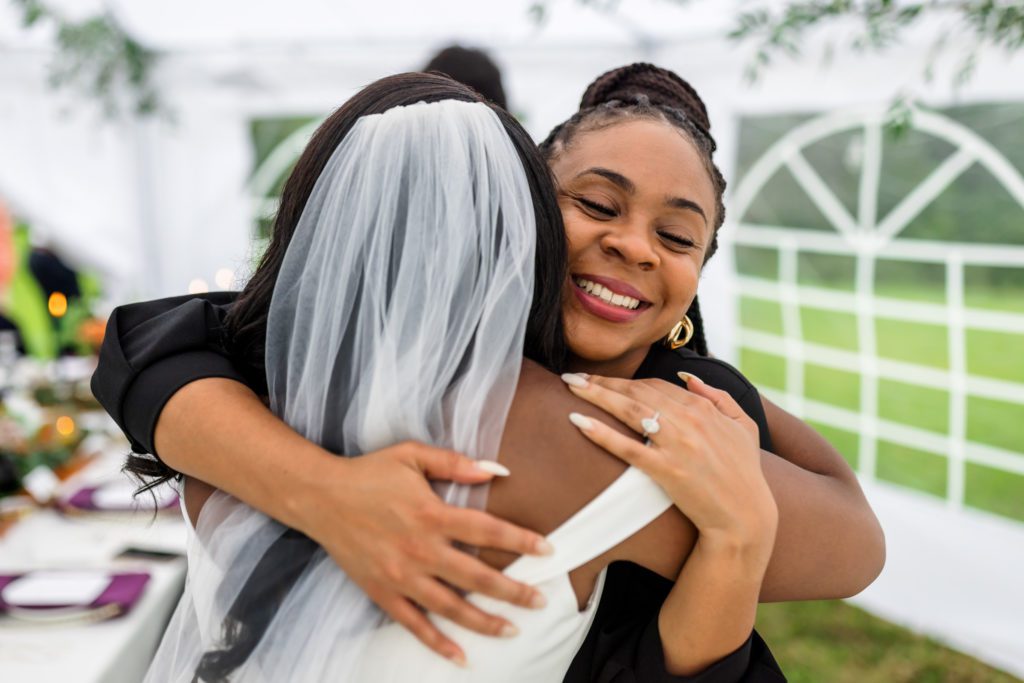 bride hugging wedding guests at outdoor wedding reception