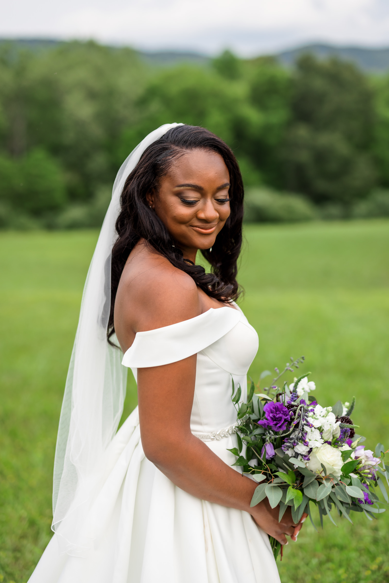 bride looking over shoulder wearing off the shoulder wedding gown