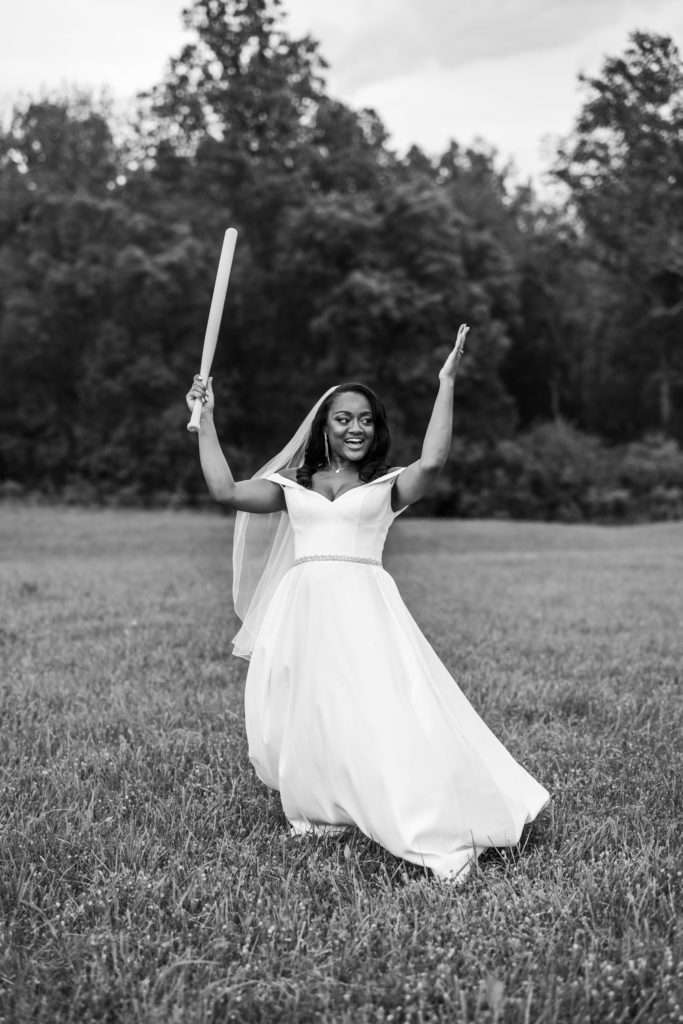 black and white image of bride celebrating after her turn during croquet