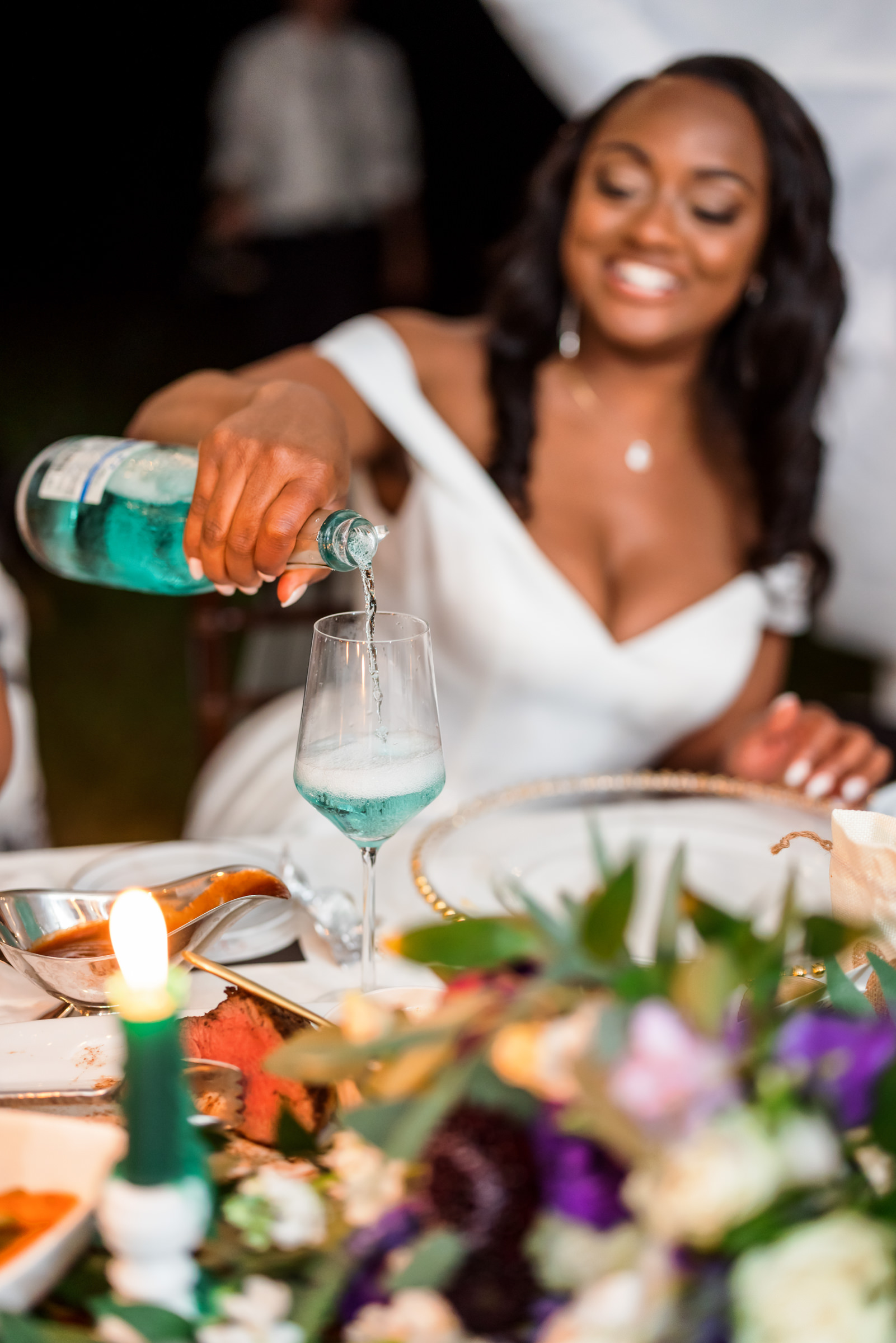 bride pouring drink at reception