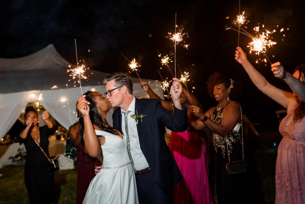 wedding couple kissing during sparkler exit after Lexington backyard wedding